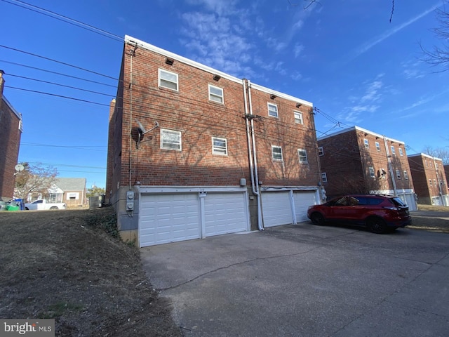 exterior space featuring a garage, central AC, and driveway