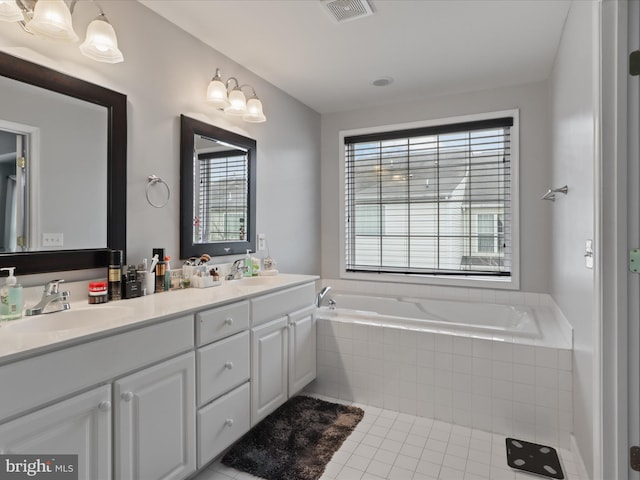 full bath with tile patterned flooring, a sink, visible vents, a bath, and double vanity