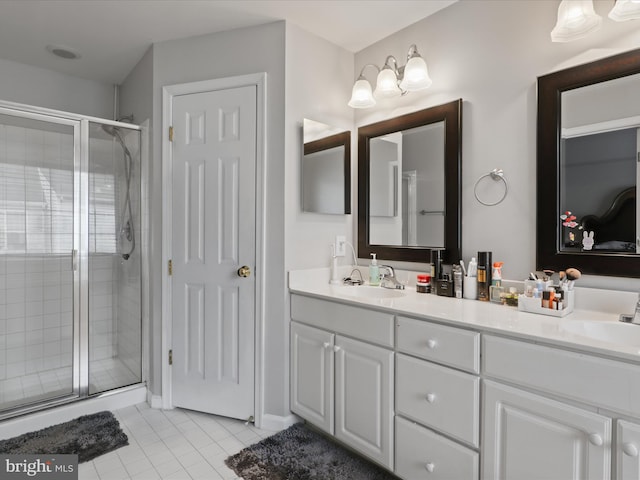 full bath with double vanity, a stall shower, tile patterned flooring, and a sink