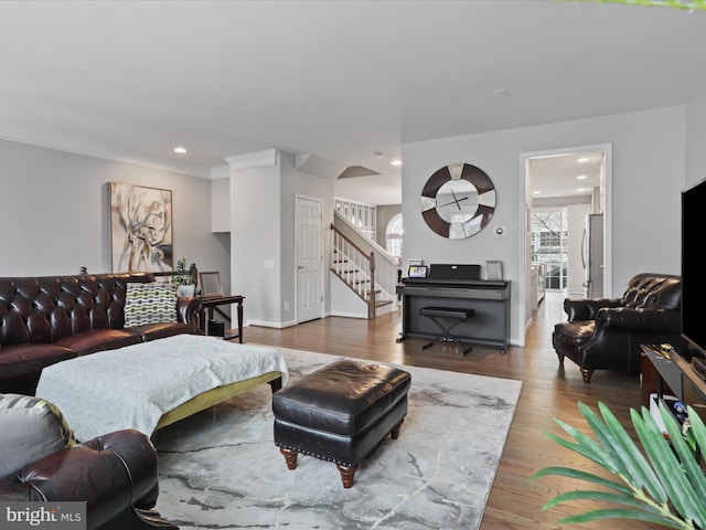 living room featuring baseboards, stairway, wood finished floors, and recessed lighting