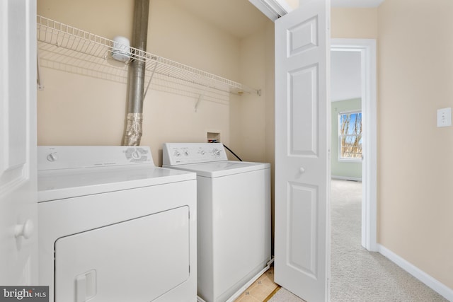 laundry room featuring laundry area, baseboards, washing machine and clothes dryer, and light colored carpet