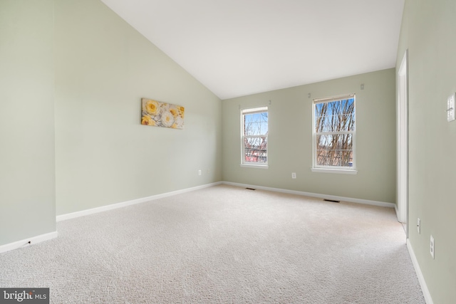 empty room featuring high vaulted ceiling, carpet flooring, visible vents, and baseboards