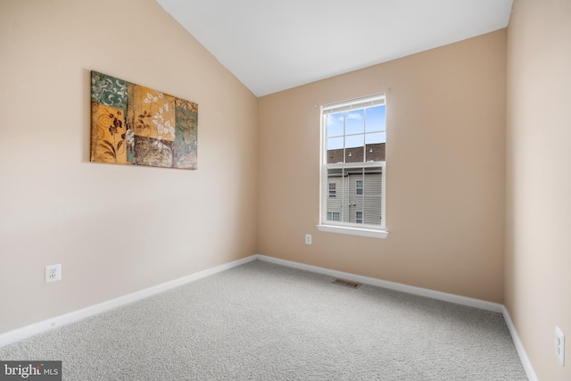 unfurnished room featuring carpet flooring, vaulted ceiling, visible vents, and baseboards