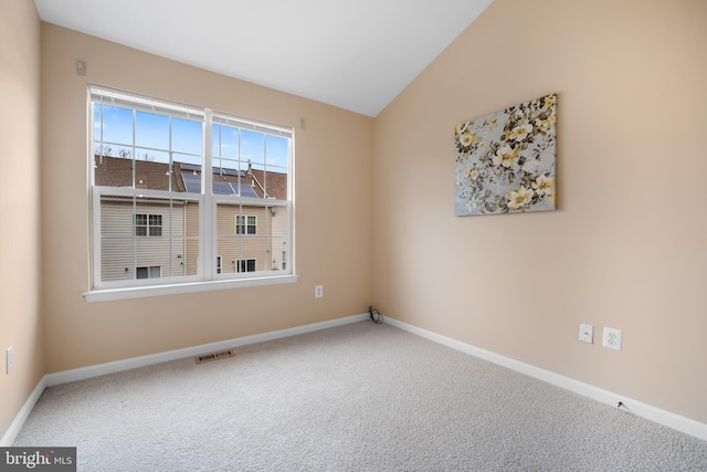 unfurnished room with baseboards, visible vents, vaulted ceiling, and carpet flooring