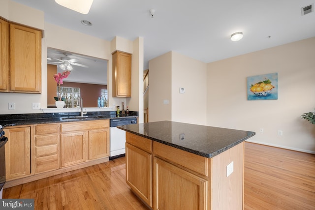 kitchen featuring visible vents, light wood-style flooring, a kitchen island, white dishwasher, and a sink