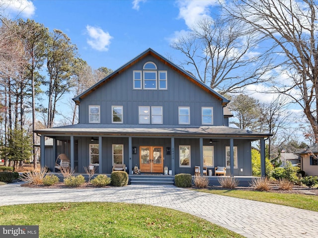 view of front of property featuring a shingled roof, covered porch, board and batten siding, and french doors