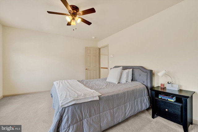 bedroom featuring light colored carpet, ceiling fan, and baseboards