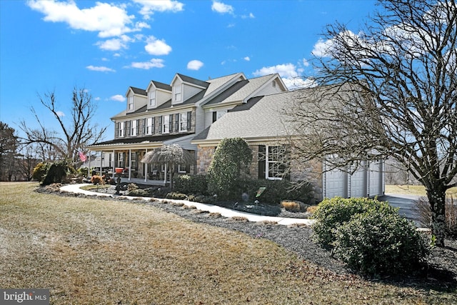 view of front of house with aphalt driveway, a porch, an attached garage, a front yard, and stone siding