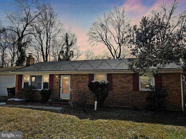 ranch-style house with a garage, brick siding, a front lawn, and a chimney