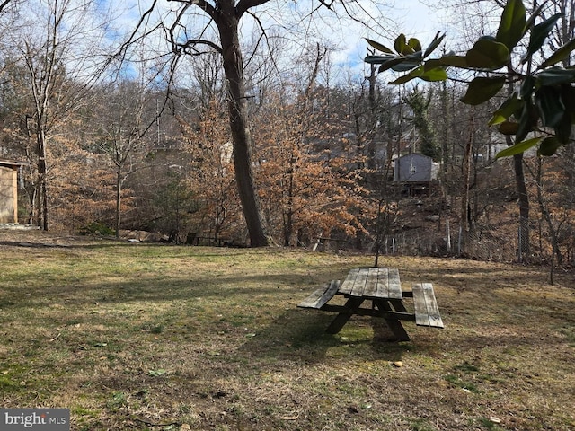 surrounding community featuring a lawn and a forest view