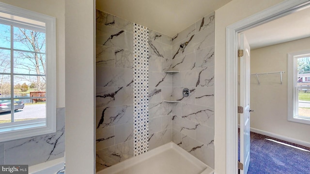 full bathroom with baseboards and a tile shower