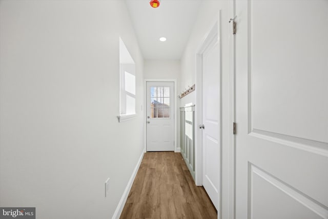 doorway with baseboards and wood finished floors