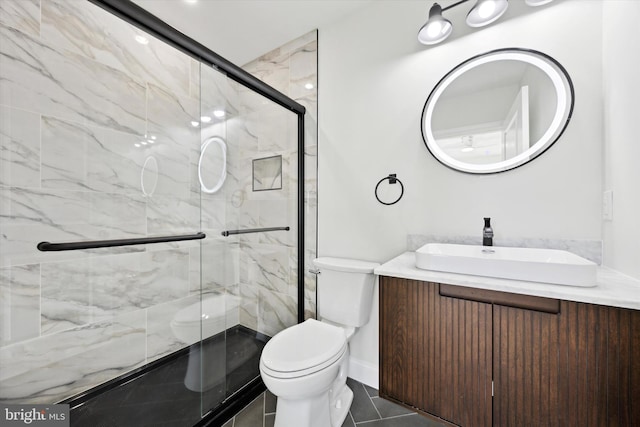 bathroom featuring toilet, a marble finish shower, and vanity