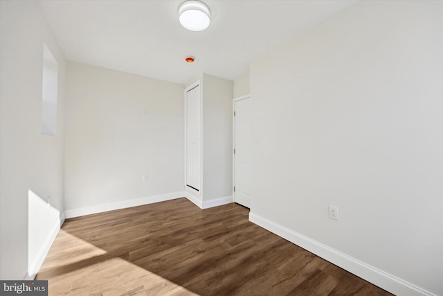 spare room with wood finished floors and baseboards