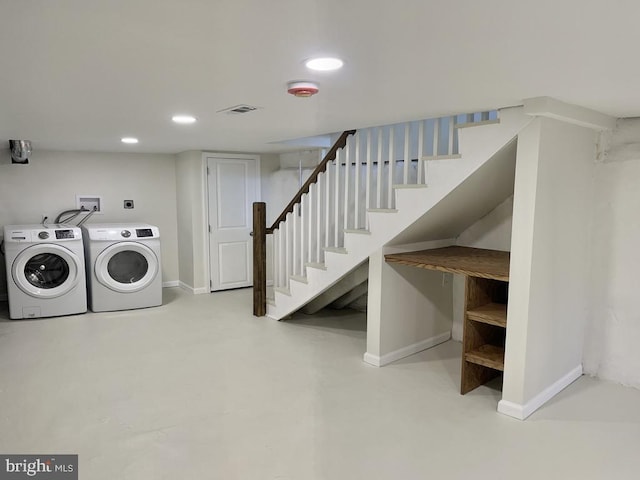 clothes washing area with washing machine and dryer, visible vents, and baseboards