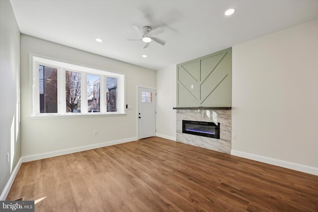 unfurnished living room featuring light wood-type flooring, a fireplace, and baseboards