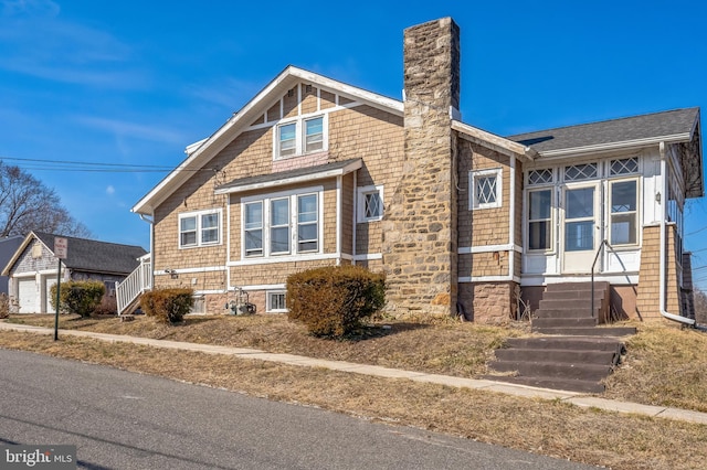 view of front of home with entry steps and a chimney