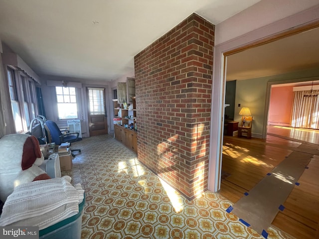 living area featuring a brick fireplace and wood finished floors