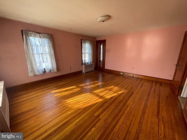 interior space with radiator heating unit, dark wood finished floors, and baseboards