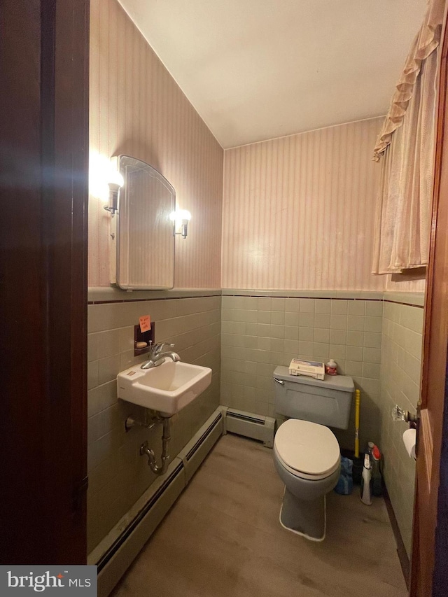 bathroom with toilet, a wainscoted wall, a baseboard heating unit, and wallpapered walls