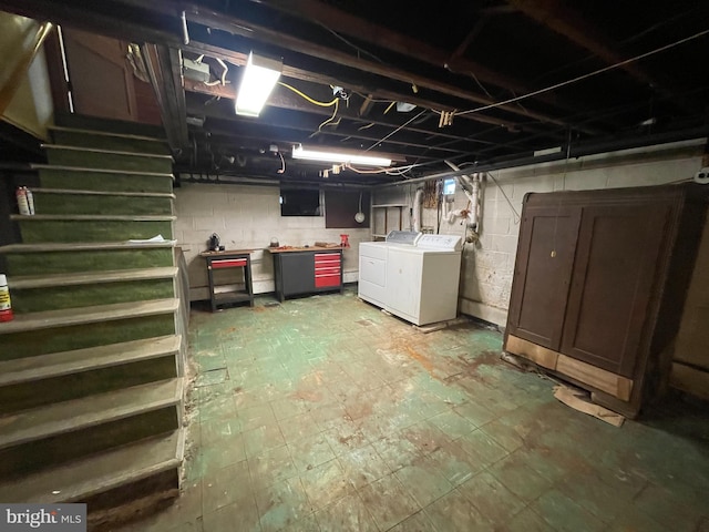 unfinished basement featuring washing machine and dryer, stairway, and tile patterned floors