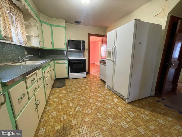 kitchen featuring white appliances, a sink, green cabinets, open shelves, and dark countertops