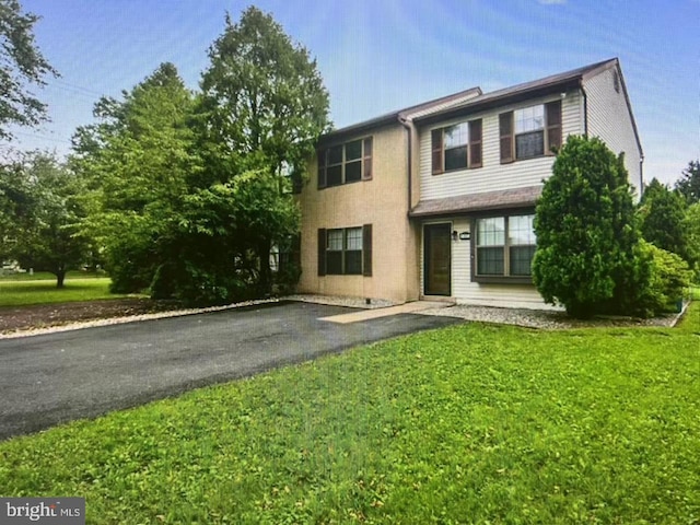 view of front of property featuring aphalt driveway and a front yard