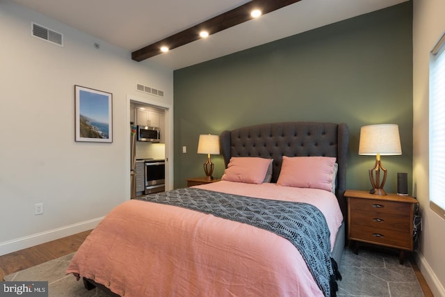 bedroom featuring beamed ceiling, dark wood finished floors, visible vents, and baseboards