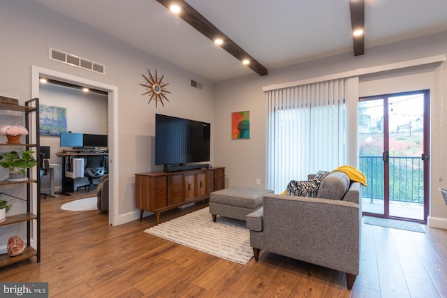 living room with visible vents, beam ceiling, and wood finished floors