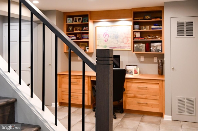 staircase featuring visible vents, built in desk, and tile patterned flooring