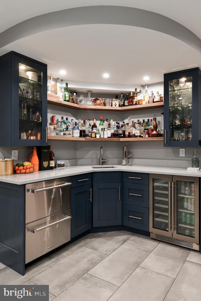 bar featuring a warming drawer, beverage cooler, a sink, light tile patterned floors, and wet bar