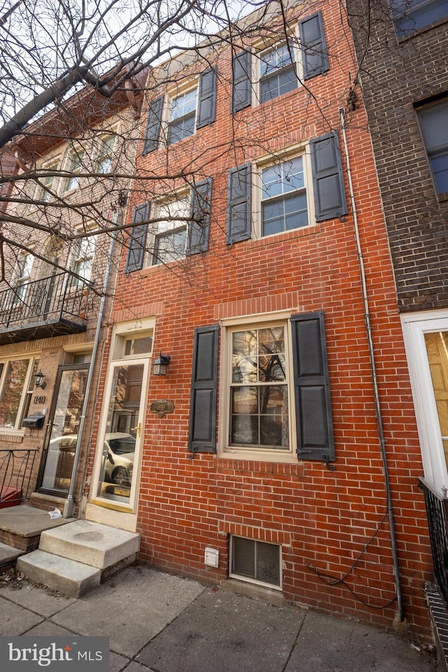 exterior space with brick siding and fence