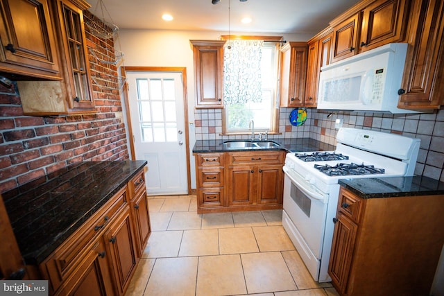 kitchen featuring white appliances, tasteful backsplash, brown cabinetry, glass insert cabinets, and a sink