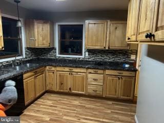 kitchen featuring light wood finished floors, decorative backsplash, dishwasher, decorative light fixtures, and a sink