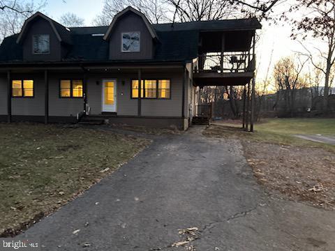 view of front of home with an attached carport, a porch, and aphalt driveway