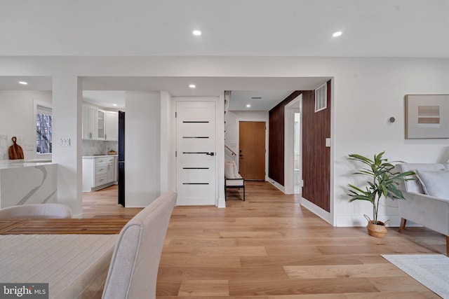 hall featuring light wood-type flooring, visible vents, and recessed lighting