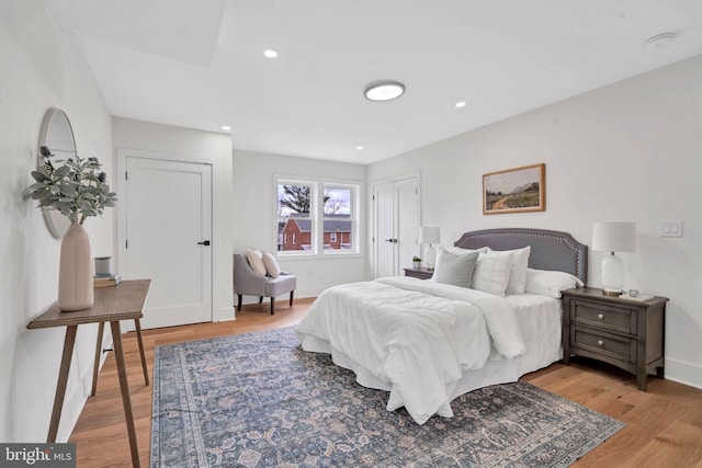 bedroom with baseboards, wood finished floors, and recessed lighting