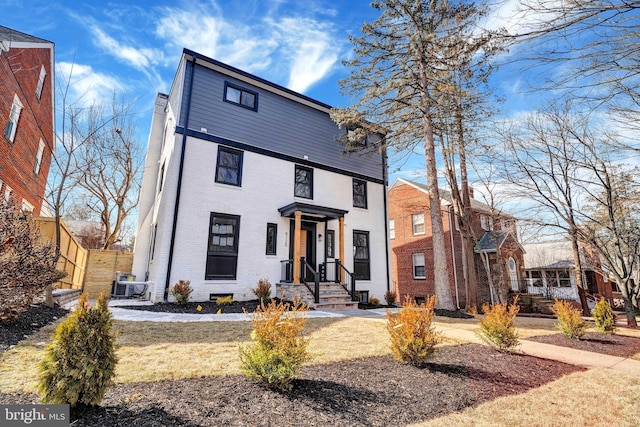 view of front of property featuring brick siding and fence