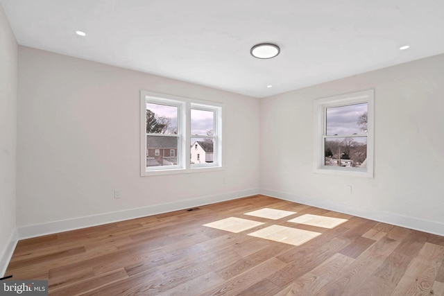 empty room with light wood-type flooring, visible vents, baseboards, and recessed lighting