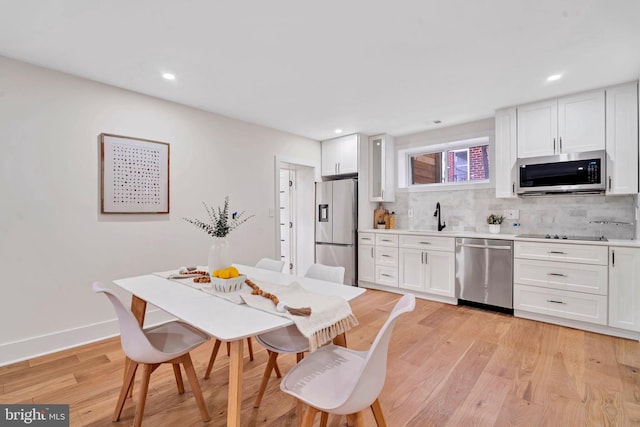 kitchen with stainless steel appliances, light countertops, and white cabinetry