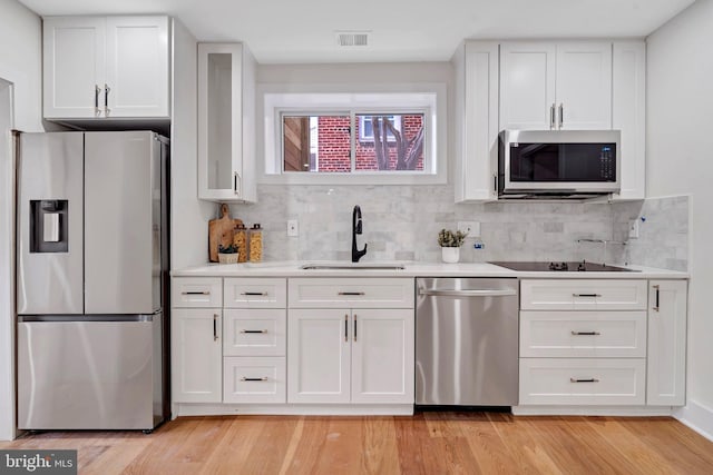 kitchen featuring stainless steel appliances, a sink, light countertops, and white cabinets