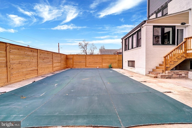 view of pool with a patio area, a fenced backyard, and stairs