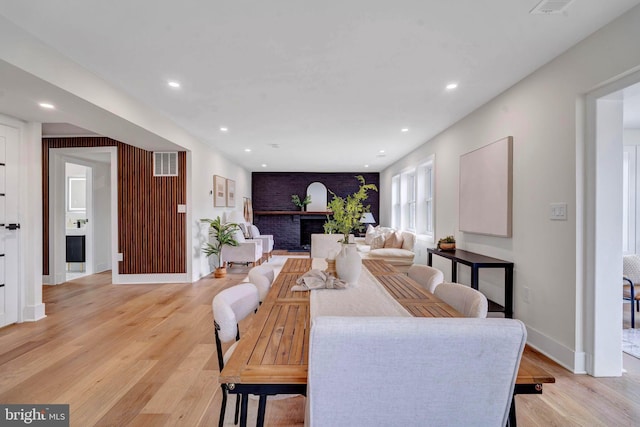 living area with light wood-type flooring, a fireplace, visible vents, and recessed lighting