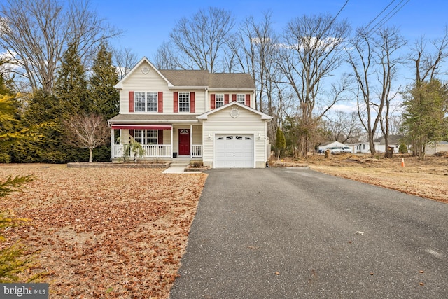 traditional-style home featuring an attached garage, aphalt driveway, and a porch