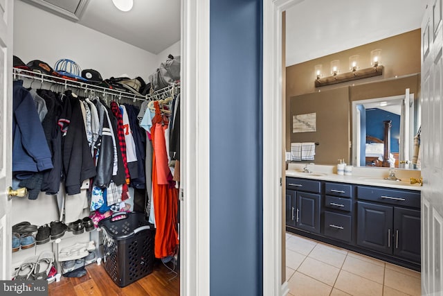 spacious closet featuring light tile patterned flooring and a sink