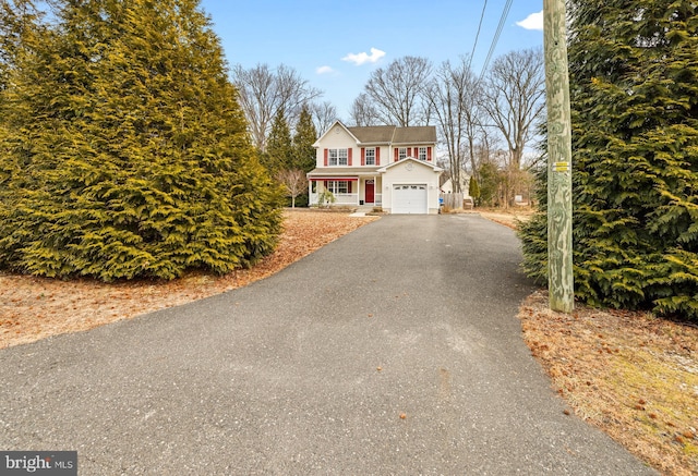 view of front of property featuring a garage and aphalt driveway