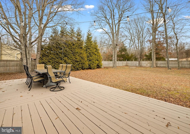 wooden deck with outdoor dining space and a fenced backyard