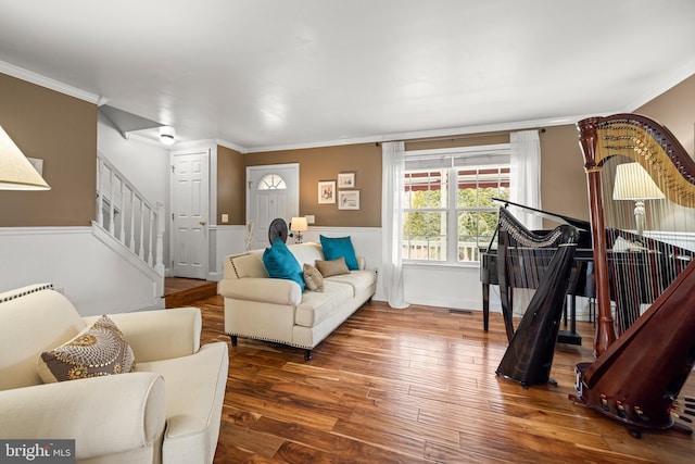 living area with stairs, ornamental molding, and wood finished floors