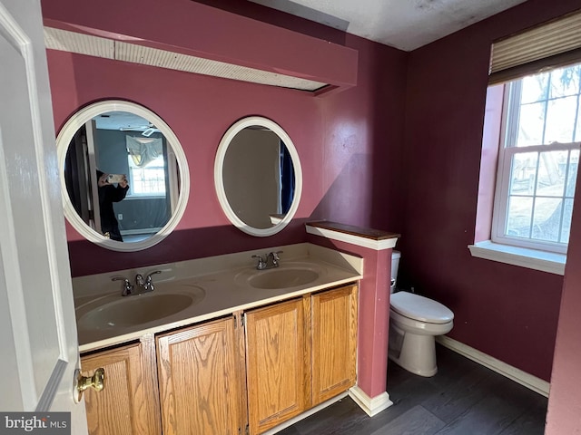 bathroom with toilet, plenty of natural light, and a sink