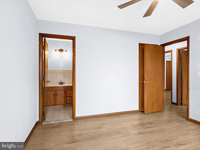 unfurnished bedroom with a ceiling fan, light wood-type flooring, connected bathroom, and baseboards